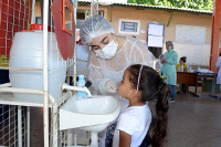 imagem mostra criança em pé proximo a um lavabo