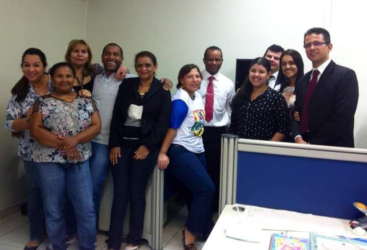 A imagem mostra a servidora Maria da Conceição com os colegas de trabalho