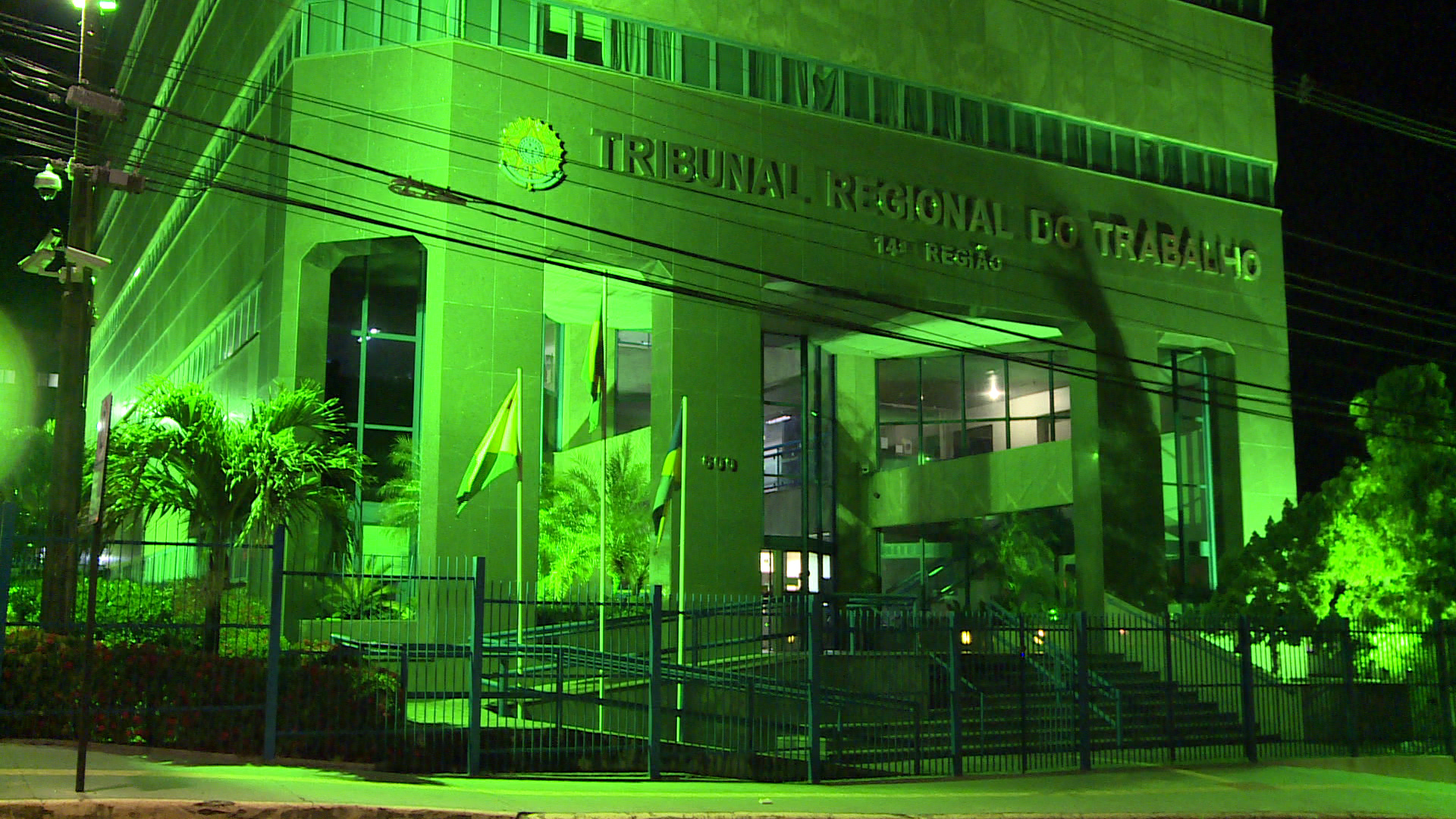 A imagem mostra a sede do TRT-14 iluminada em verde, cor símbolo da campanha de prevenção ao acidente de trabalho e doenças ocupacionais