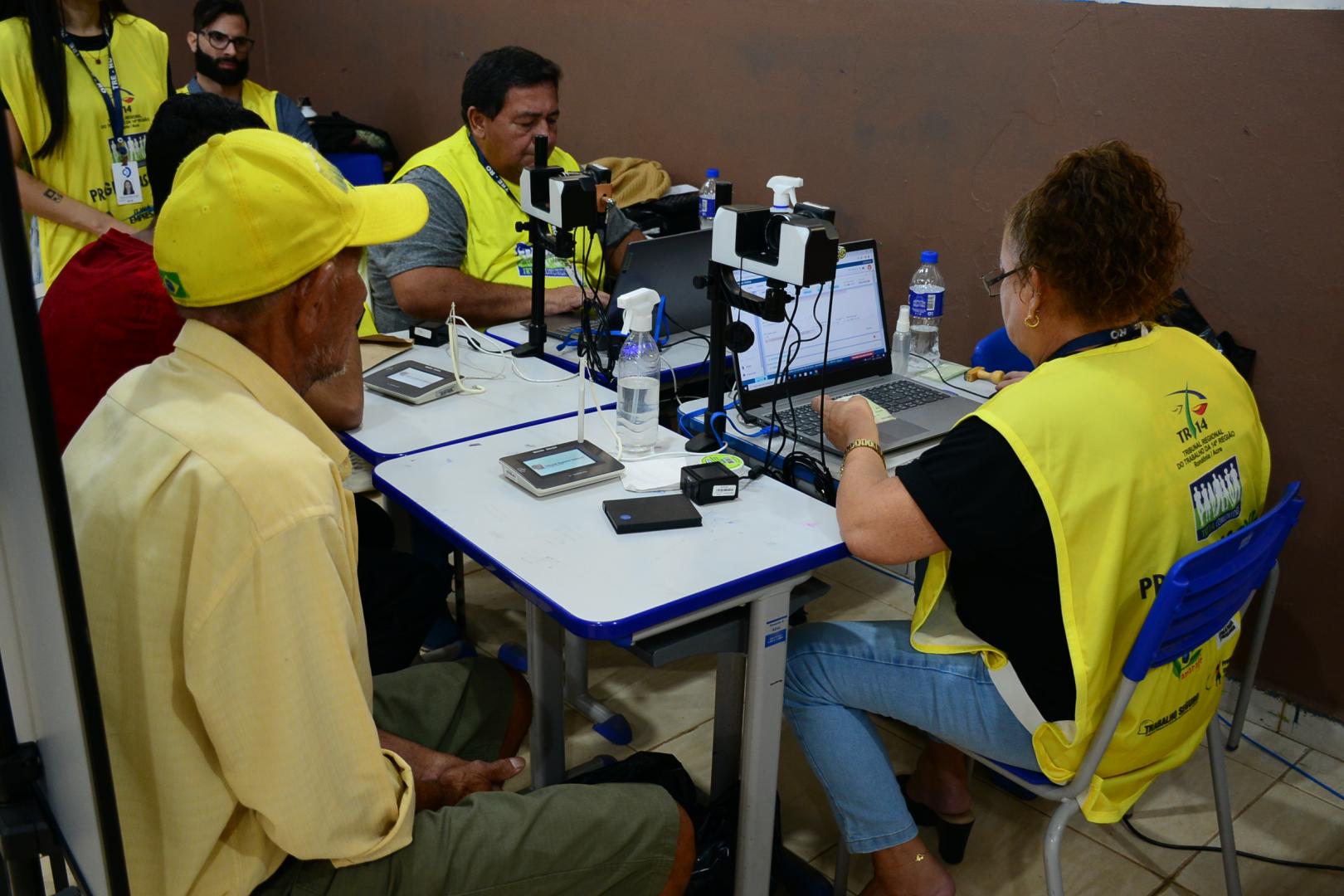 A imagem mostra pessoas recebendo atendimento no TRE.