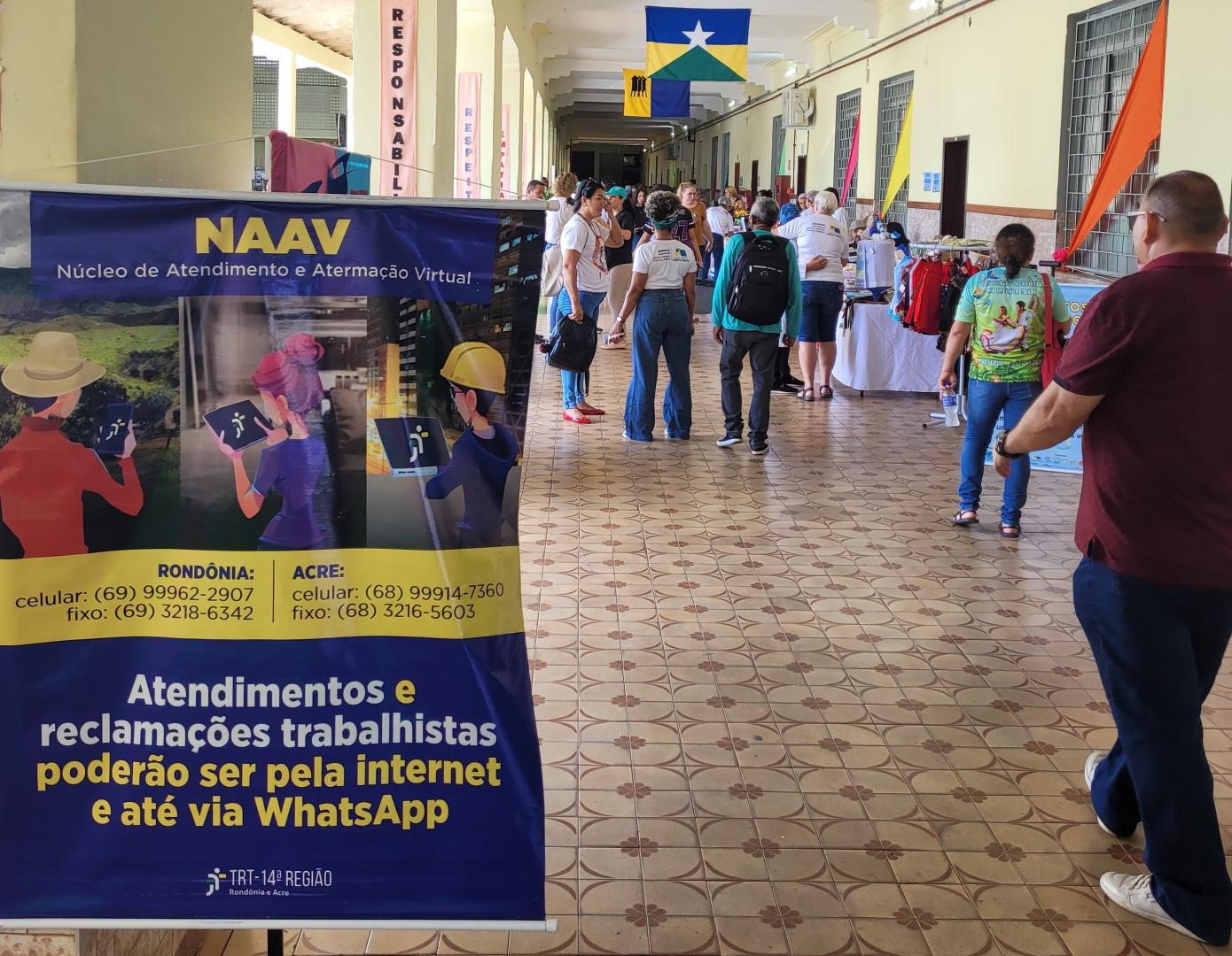 A imagem monstra o corredor da escola e em primeiro plano o banner do NAAV