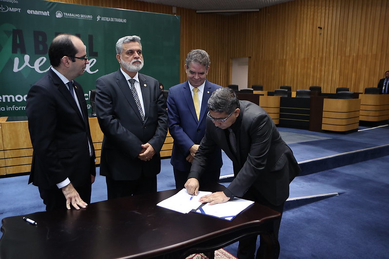 A imagem mostra o juiz do Trabalho do TRT-14, Edilson Carlos Cortez assinando o Acordo de Cooperação para saúde e segurança no trabalho, durante cerimônia no TST.