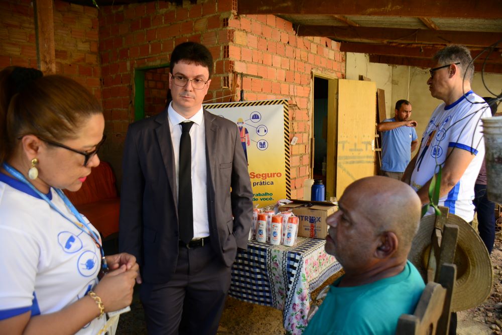 Foto do magistrado e servidores(as) do TRT-14 conversando com catadores de materiais recicláveis.