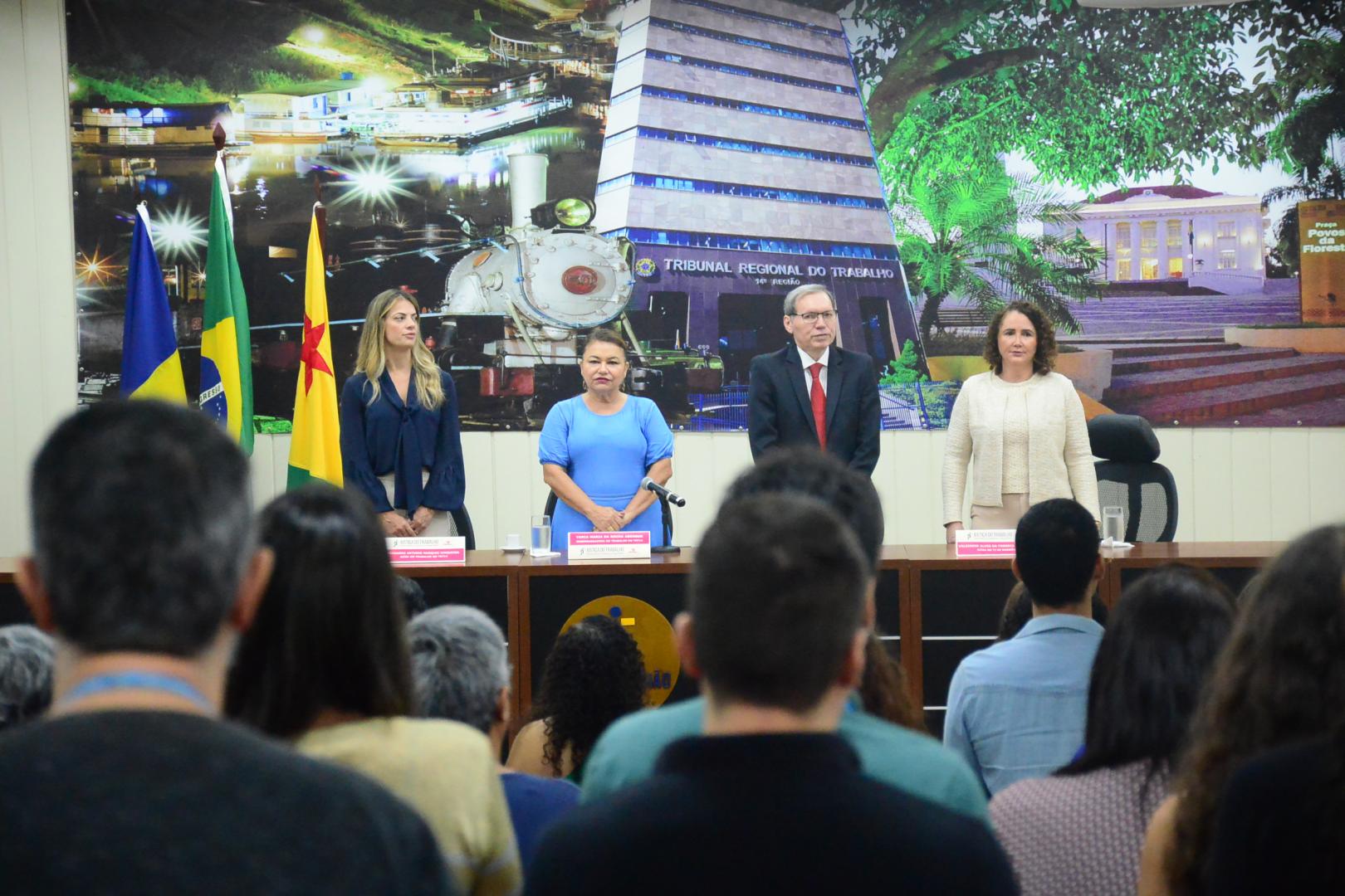 A imagem mostra auditório lotado durante palestra