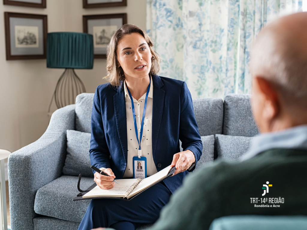 Imagem mostra uma mulher fazendo cadastro de um idoso que esta de costa. 