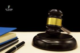 A imagem mostra um martelo, um livro e uma caneta sobre uma mesa.