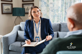 Imagem mostra uma mulher fazendo cadastro de um idoso que esta de costa. 